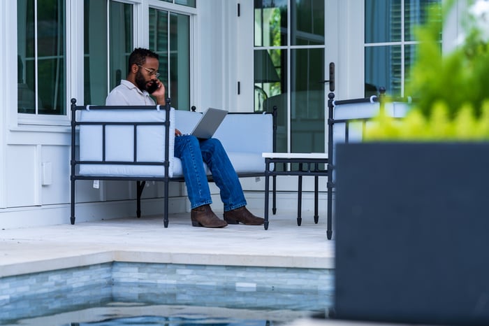 client sitting outdoor seating computer on phone