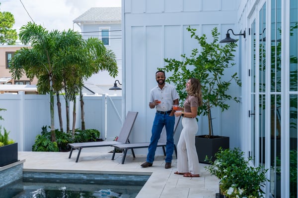 clients having a drink on patio near pool and smiling