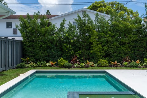 colorful landscape beds along grass and pool