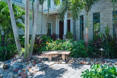 paver walkway front of house landscape beds seating bench