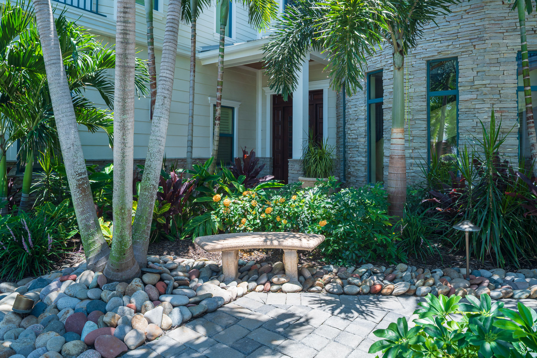 paver walkway front of house landscape beds seating bench